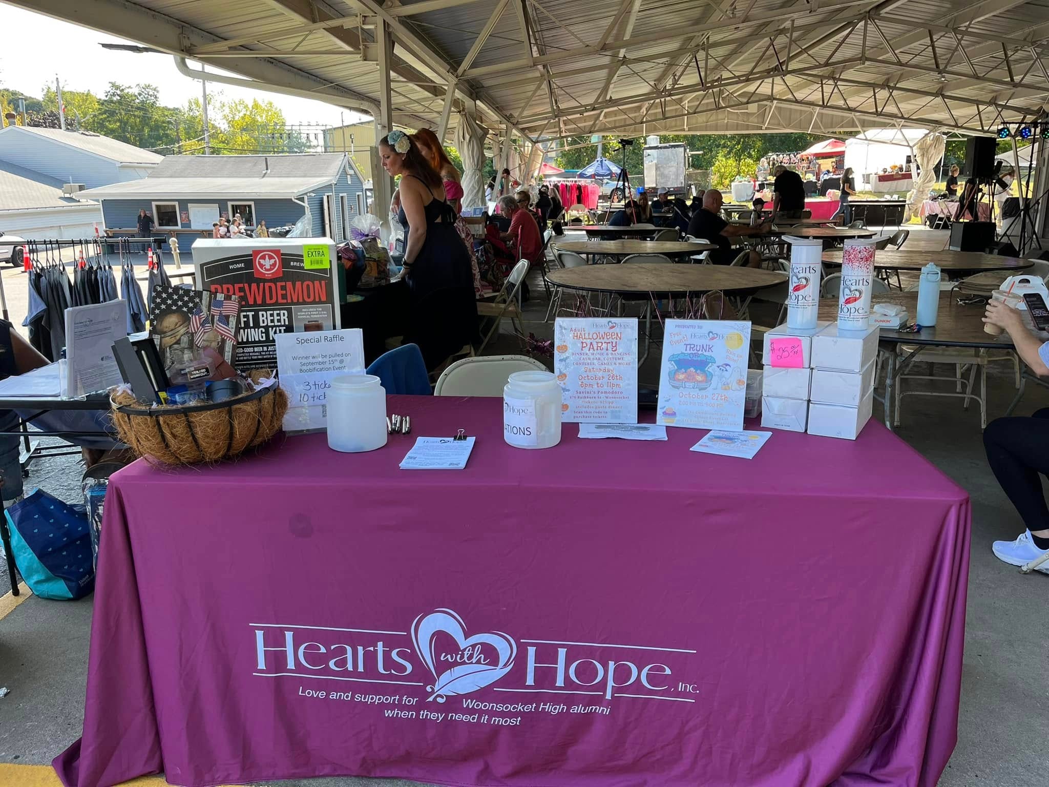 Hearts with Hope branded table at outdoor community event with raffle items