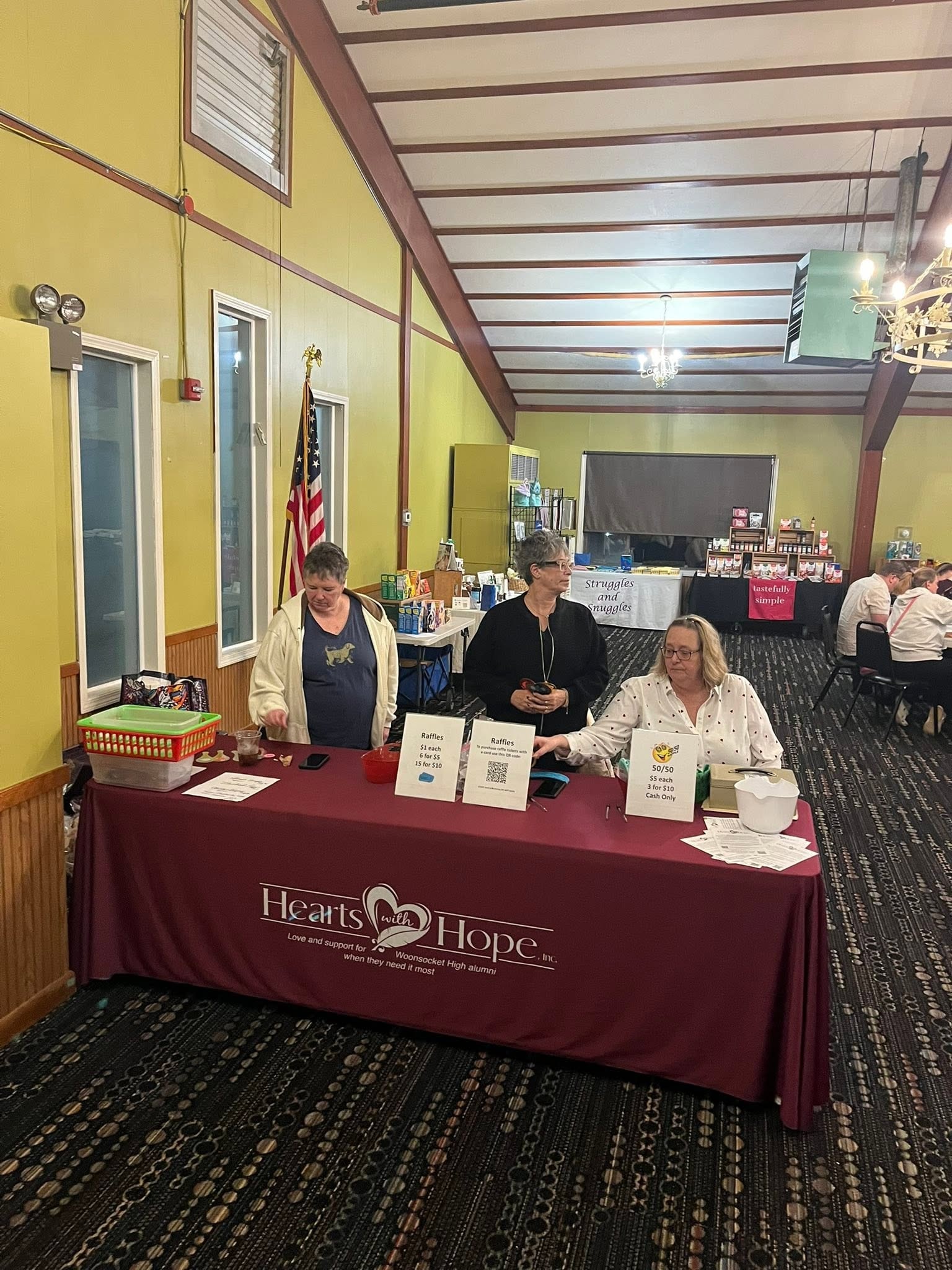 Hearts with Hope volunteers at the raffle and 50/50 table at a fundraiser event
